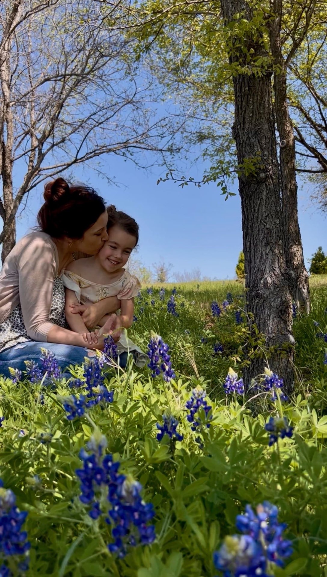 Alyssa kissing her daughter among the bluebonnets